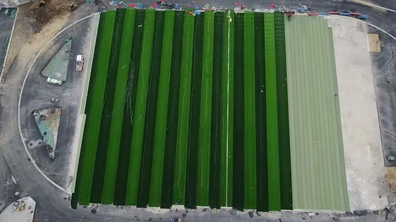 Artificial turf rolls laid out on a football pitch during installation